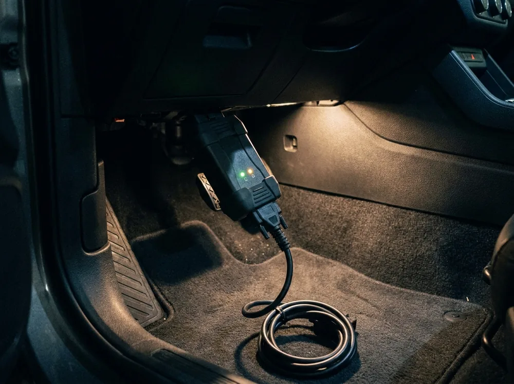 A key programming tool plugged into a car's diagnostic port